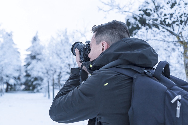 fotografía de un hombre con cámara reflex haciendo fotografía de paisajes